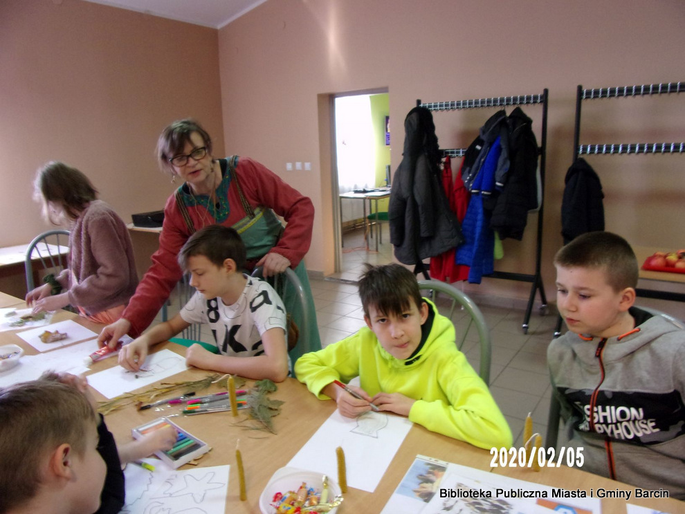 Uczestnicy aktywnie biorą udział w zajęciach, rysując i wyklejają prace