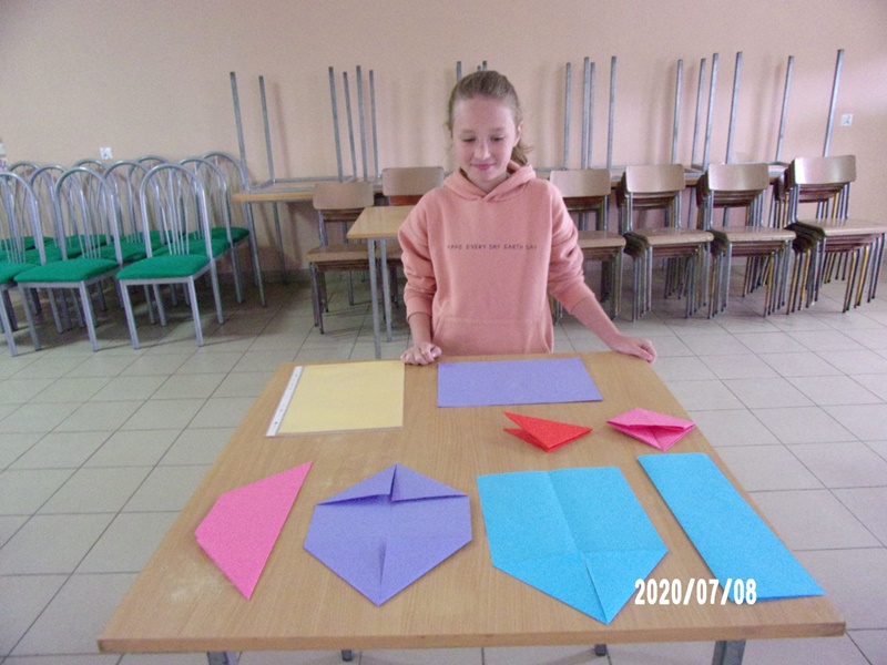 Prowadząca pokaz origami dziewczynka przygotowuje się do zajęć.