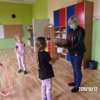 Uczestniczki zajęć wręczają pani bibliotekarce kwiaty w podziękowaniu za zorganizowane zajęcia.