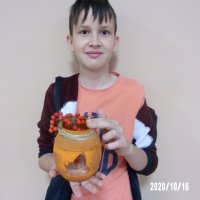 Chłopiec prezentuje swój pomarańczowy lampion w kształcie baryłki.