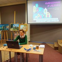Osoba prowadząca warsztat "Rodzinnie o języku" siedzi przy komputerze.