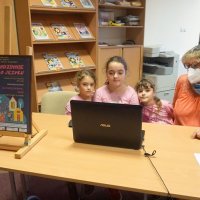 Mama z trzema córkami, uczestniczki warsztatu dla rodzin Rodzinnie o języku on-line siedzą przed komputerem.