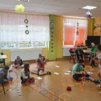 Dzieci samodzielnie i w grupach tworzą rozmaite kształty z kolorowych patyczków.