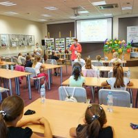 Panie bibliotekarki z oddziału dla dzieci rozpoczynają spotkanie, zebrane dzieci siedzą przy stołach.