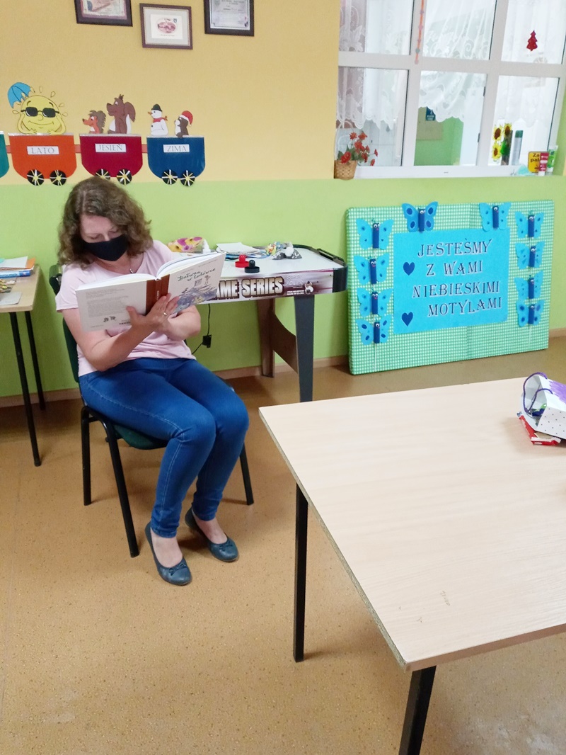 Pani bibliotekark czyta uczestnikom ksiażkę.