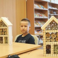 Troje uczestników zajęć z gotowymi domkami, po wypełnieniu domków na przodzie została przymocowana czarna siatka o większych oczkach, która zabezpiecza zawartość przed wypadnięciem.