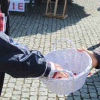 Na zdjęciu widać jak jeden z uczestników dożynek i Narodowego Czytania losuje konkursowy kotylion.
