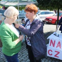 Pani Anna Zielińska przypina jednej z uczestniczek wydarzenia konkursowy kotylion.