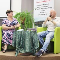 Pan Wojciech mówi do mikrofonu a Pani Grażyna słucha wypowiedzi.