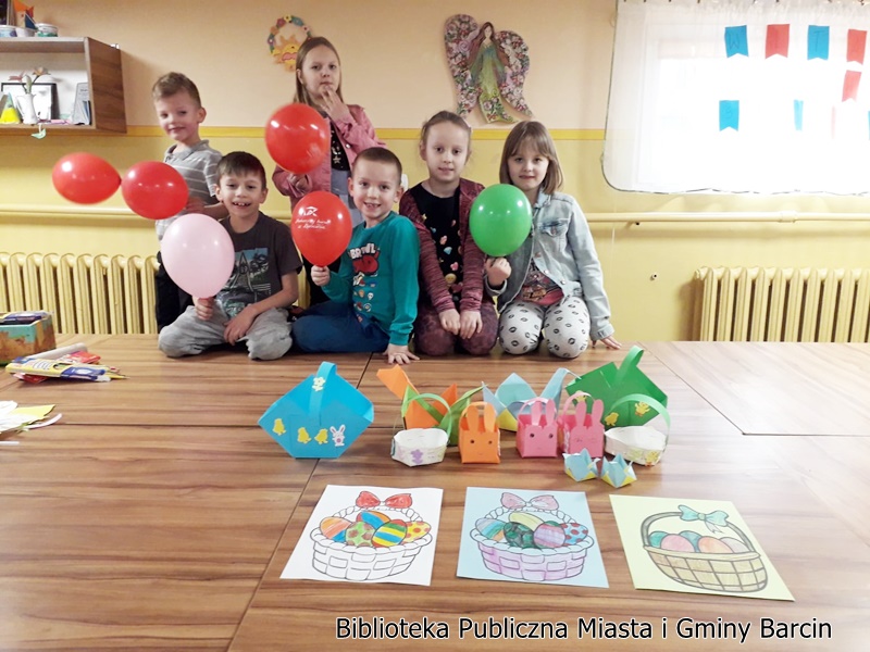 Grupowe zdjecie na którym widać dzieci i wykonane przez nie prace