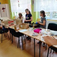 Czwórka dzieci podczas pracy na zajęciach wybiera materiały z których będą wykonywali swoje prace.