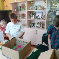 Trzech chłopców podczas pracy, jeden ma w kartonie przyklejony kolorowy papier.