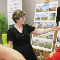 Pani Grażyna Błaszkiewicz opowiada o odwiedzonych miejscach, pokazując zdjęcia dotyczące danej opowieści.