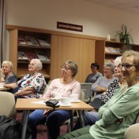 Zdjęcie osób z publiczności, które z uwagą słuchają opowieści zaproszonego gościa.