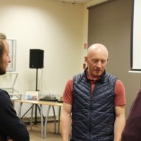 Pan Maciej Stańczak rozmawia po spotkaniu z dwoma uczestnikami.