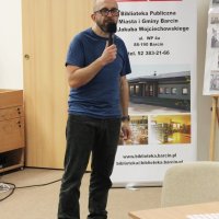 Robert Robb Maciąg stoi z mikrofonem w ręce i słucha pytania zadanego przez jednego z widzów.