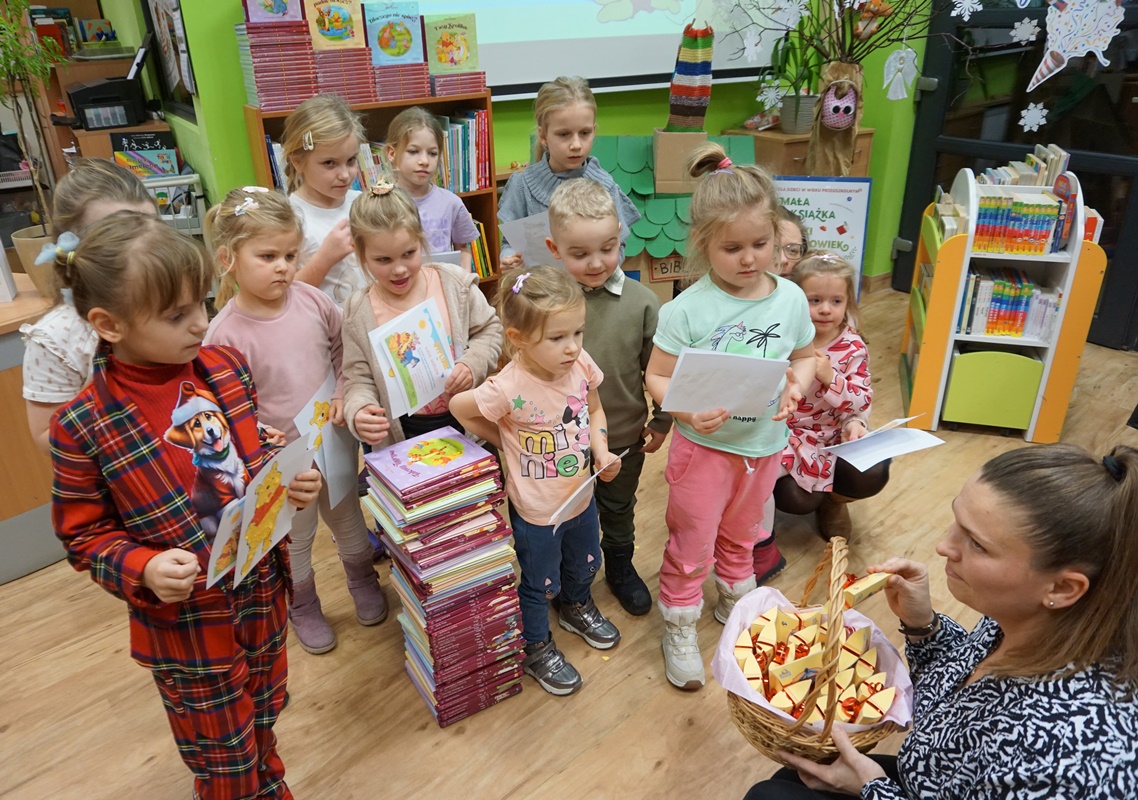 grupa przedszkolaków słucha wypowiedzi pani bibliotekarki