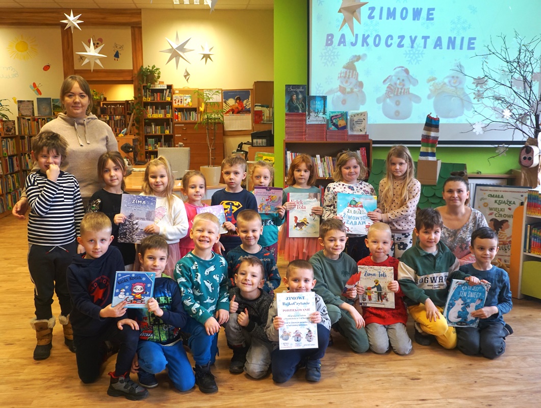 grupowe zdjęcie uczestników lekcji, dzieci trzymają w rękach książki o tematyce zimowej