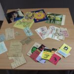 Eksponaty z czasu PRL przywiezione przez zaproszonego gościa, widać pocztówki, banknoty oraz kartki na zakup różnych przedmiotów