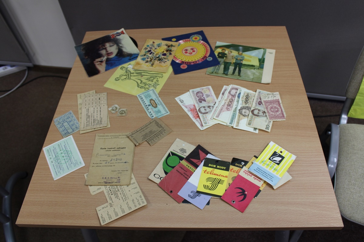 Eksponaty z czasu PRL przywiezione przez zaproszonego gościa, widać pocztówki, banknoty oraz kartki na zakup różnych przedmiotów