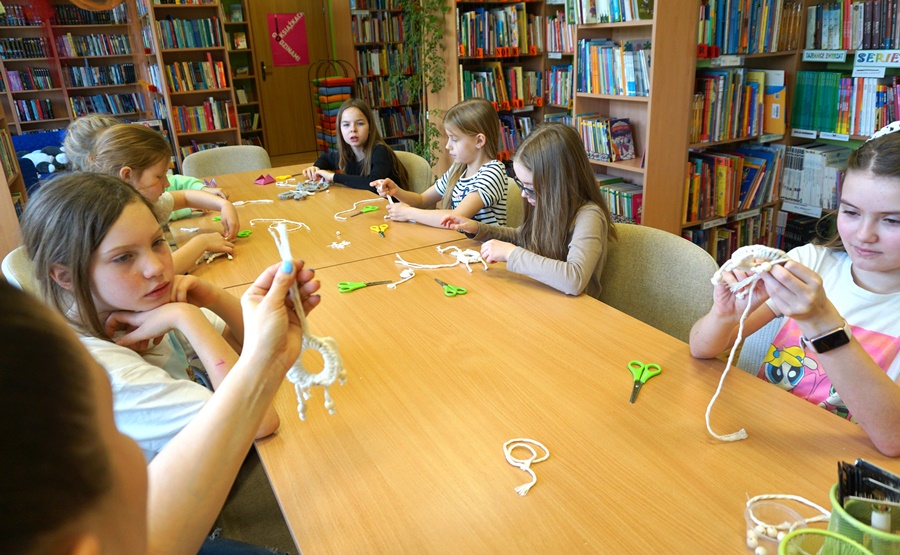 Bibliotekarka pokazuje jak należy wykonać kolejną czynność podczas zajęć, uczestniczki powtarzają jej ruchy