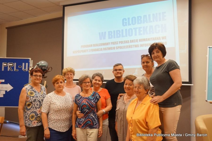 Grupowe zdjęcie 10 osób w tle na ekranie projektora widać napis GLOBALNIE W BIBLIOTEKACH