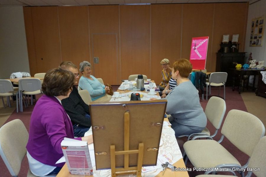 Zdjęcie zebranych uczestników spotkania przy stolikach.