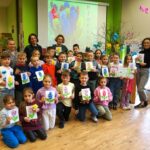 Grupowe zdjęcie uczniów, nauczycielki i bibliotekarki wykonane po zajęciach