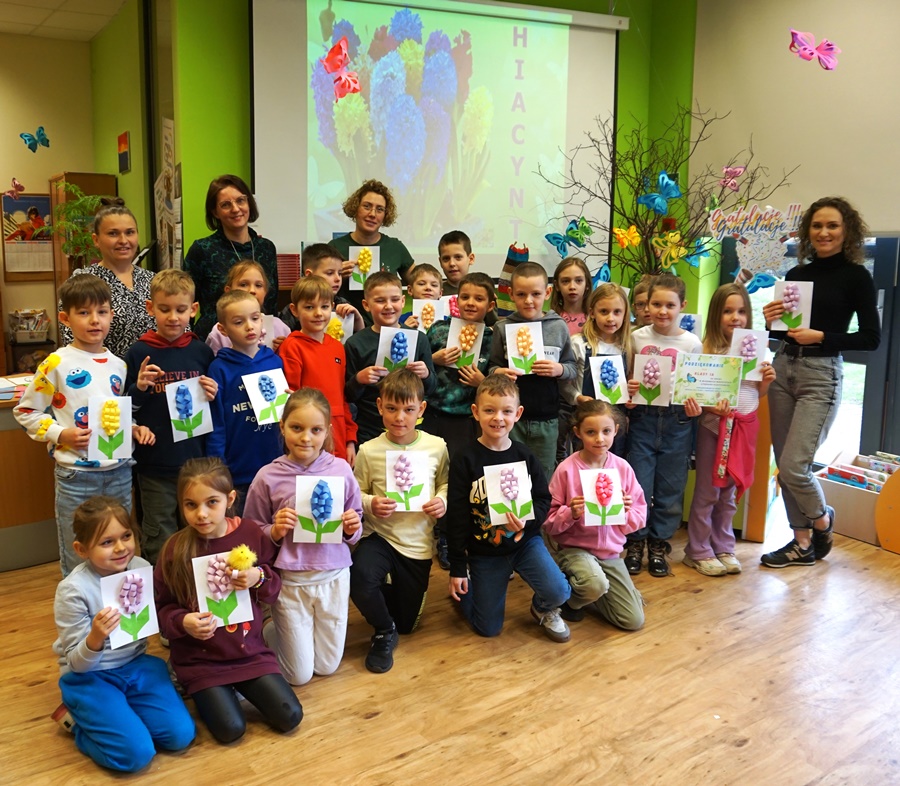 Grupowe zdjęcie uczniów, nauczycielki i bibliotekarki wykonane po zajęciach