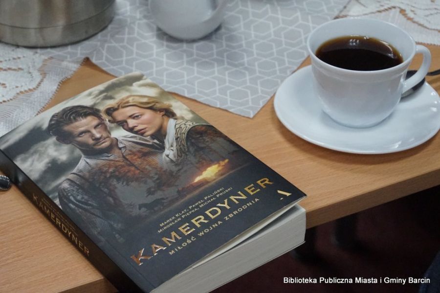 Zdjęcie omawianej książki leżącej na stole obok filiżanki z kawą.