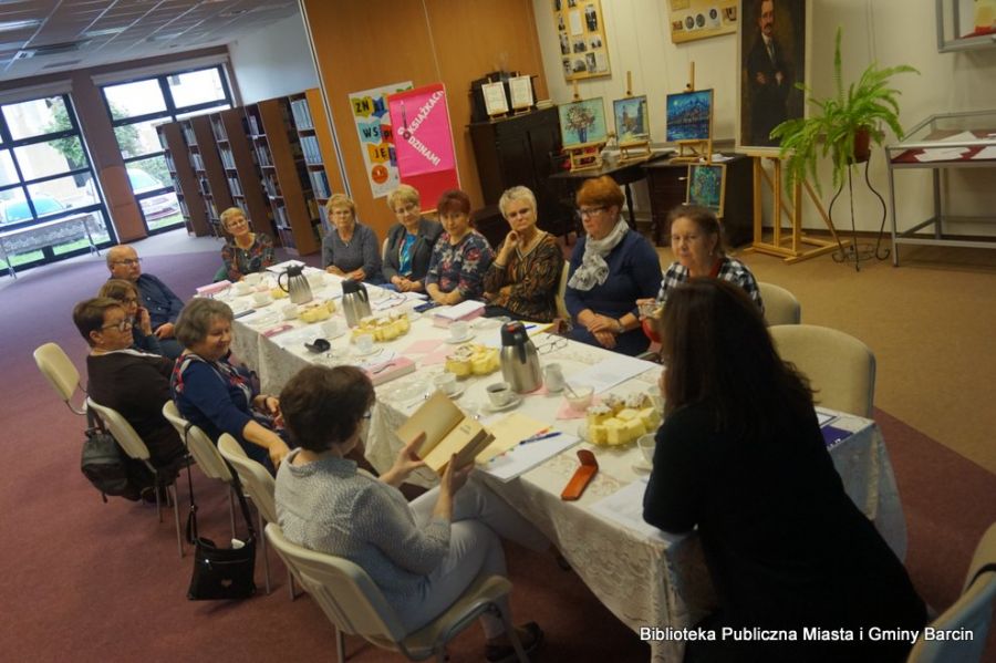 Zdjęcie zebranych uczestników siedzących przy stolikach, widać trzynaście osób.