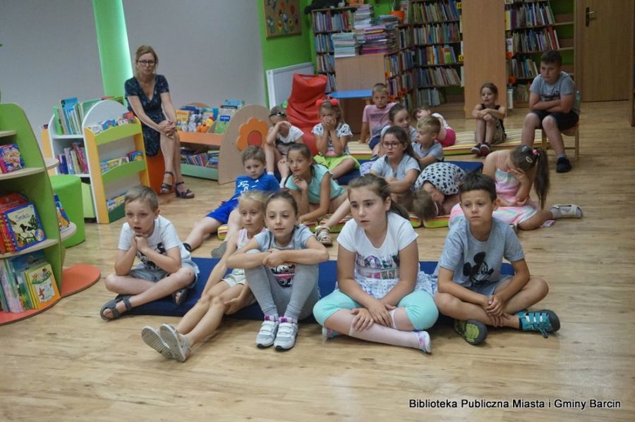 grupa dzieci siedzi na materacach, za nimi siedzi wychowawczyni.