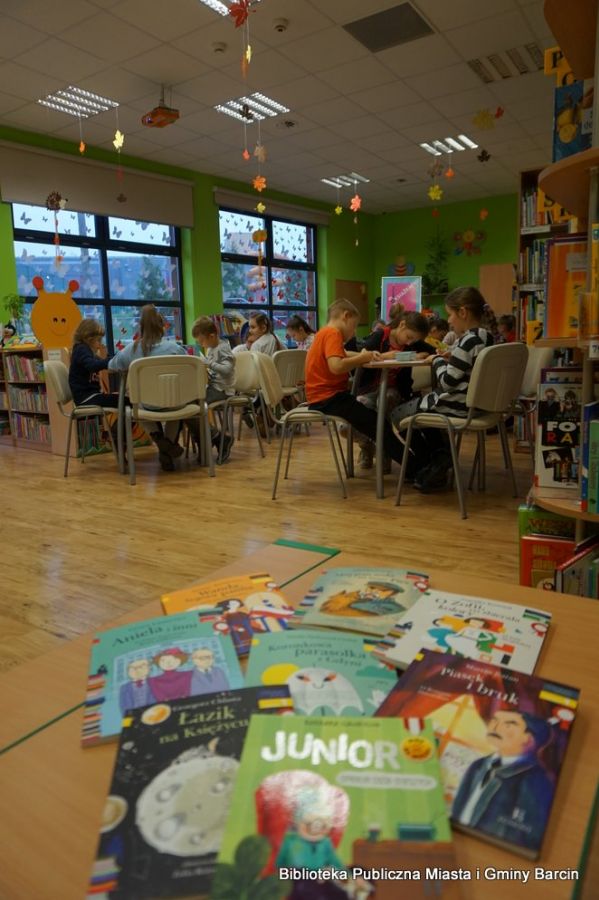 Na zdjęciu widać książki dla dzieci oraz zebranych uczestników zajęć.
