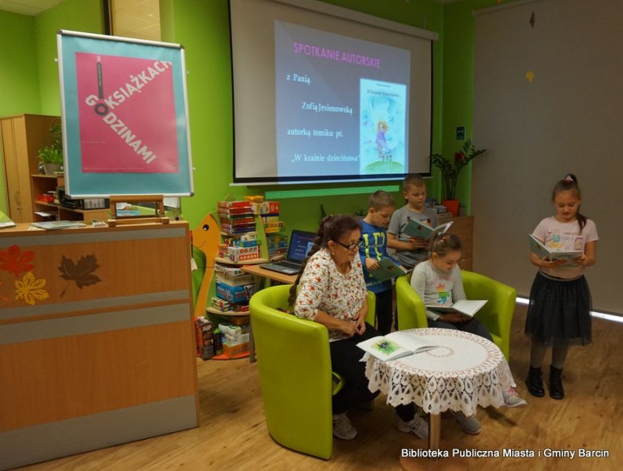 Dzieci wraz z Panią Zofią czytają fragmenty wierszyków z książki "W krainie dzieciństwa"