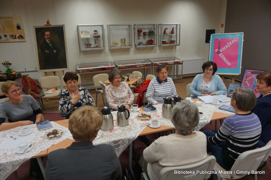 Zdjęcie zebranych gości, widać dziewięć osób siedzących przy rzędzie stołów.