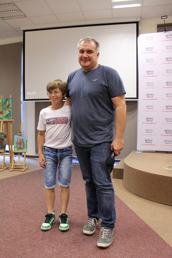Pan Marcin Kostrzyński pozujący do zdjęcia z jednym z widzów uczestniczących w spotkaniu.