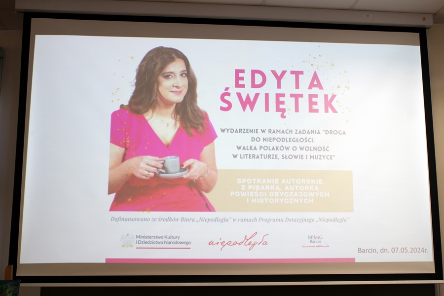 Plakata informujący o spotkaniu wyświetlany na ekranie projektora.