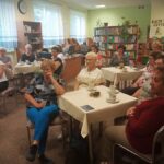 osoby zgromadzone w bibliotece z uwagą słuchają tego o czym mówi Aneta Obarska