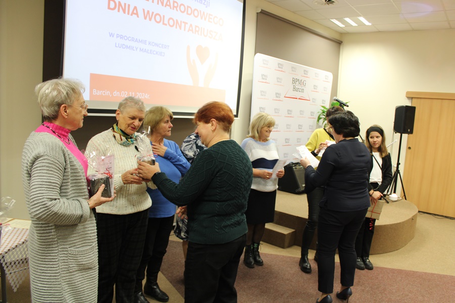 dyrektorka biblioteki i pracownica filii nr 1 wręczają upominki i podziękowania wolontariuszom
