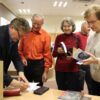 autor podpisuje książki dla czytelników, którzy stoją w kolejce