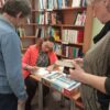 Zaproszona autorka podpisuje książkę dla czytelnika