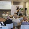 Autor stoi na scenie przed zebraną publicznością i śpiewa swój wiersz grają dodatkowo na gitarze
