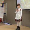 Dziewczynka podczas występu na scenie mówi wiersz do mikrofonu