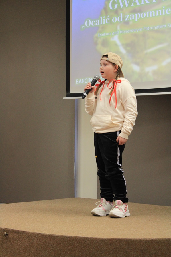 uczestniczka konkursu recytuje wiersz przed jury i publicznością