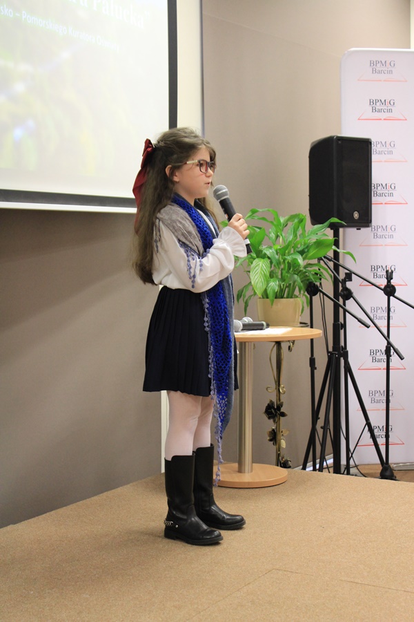 uczestniczka konkursu recytuje wiersz przed jury i publicznością