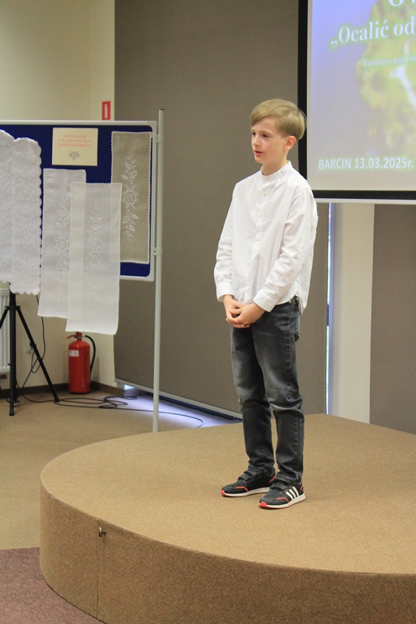 uczestnik konkursu recytuje wiersz przed jury i publicznością