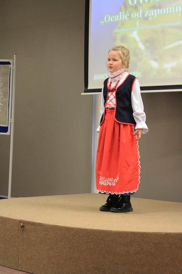 uczestniczka konkursu recytuje wiersz przed jury i publicznością