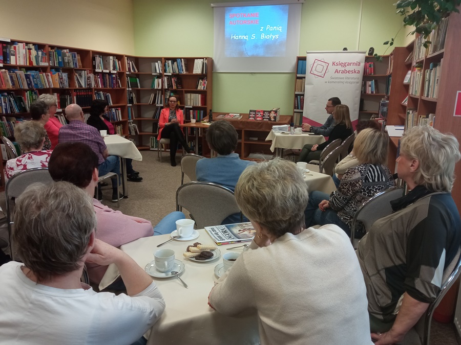 publiczność obecna na spotkaniu słucha zaproszonego gościa