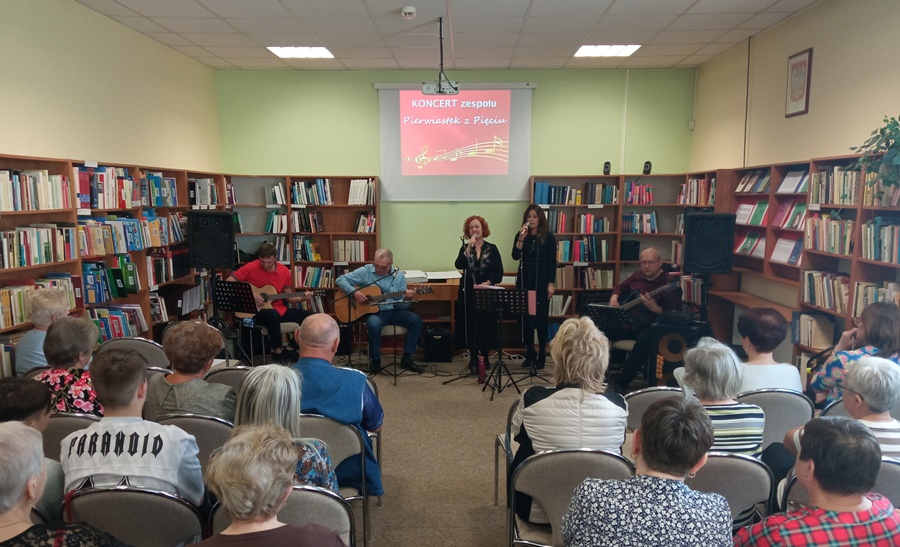 5 osobowy zespół składający się z 3 gitarzystów i 2 wokalistek występuje przed publicznością
