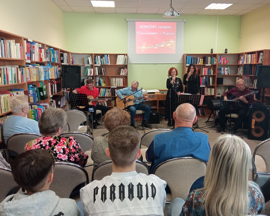 5 osobowy zespół składający się z 3 gitarzystów i 2 wokalistek występuje przed publicznością